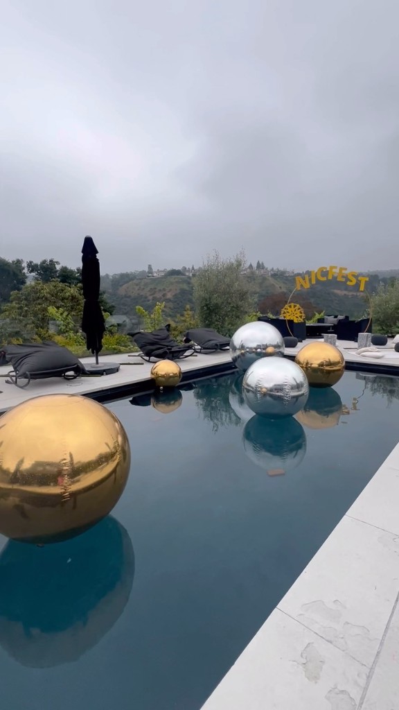 Gold and silver metallic spheres floating in a pool at a NICFEST outdoor event