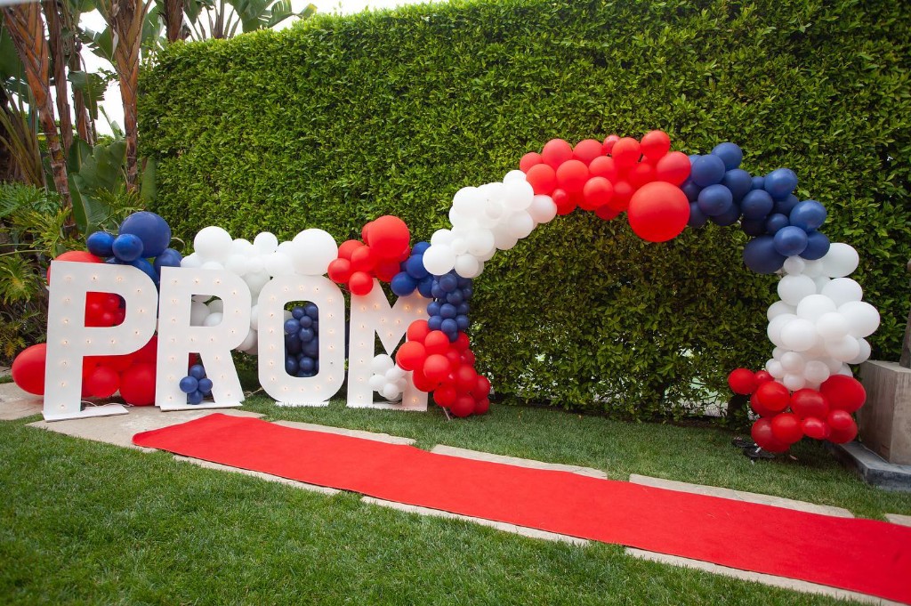PROM marquee letters with red, white, and navy balloon arch and red carpet