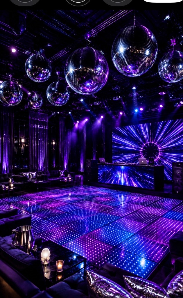 Nightclub interior with purple LED dance floor, disco balls, and DJ booth